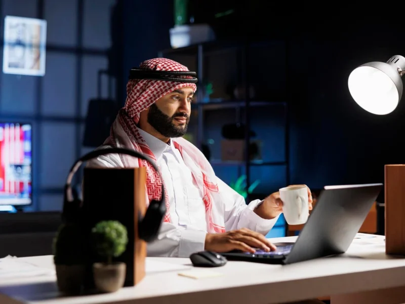 side-view-muslim-guy-holding-cup-coffee-surfing-net-his-digital-laptop-image-showcasing-male-arab-person-engrossed-his-personal-computer-while-drinking-tea_482257-70630